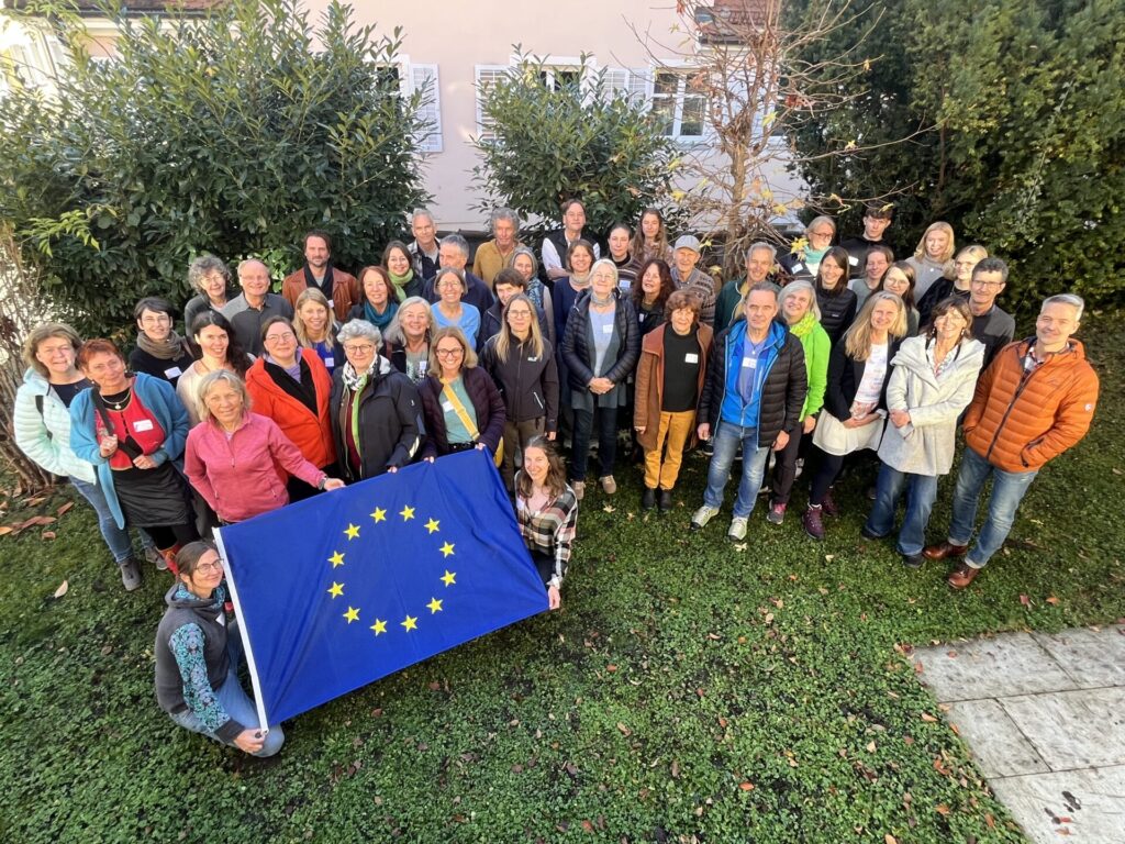 Gruppenfoto der Teilnehmer*innen des Blühbotschafterkongress in Lindau. Vorne links halten vier Teilnehmer*innen eine große Europaflagge in der Hand.