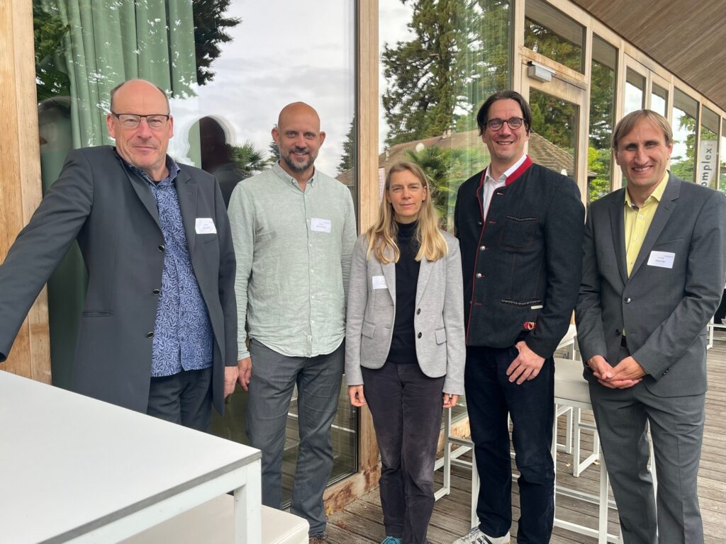 Das Bild ist ein Gruppenfoto mit 5 Personen. Von links: Bene Müller (solarcomplex AG, Volker Kromrey (Bodensee-Stiftung), Anja Peck (Landesforstverwaltung BW) und Björn Graf Bernadotte (Mainau GmbH). Rechts im Bild Prof. Dr. Michael Sterner (IFES Institut für Energiespeicher GmbH), Keynotespeaker der Veranstaltung.
