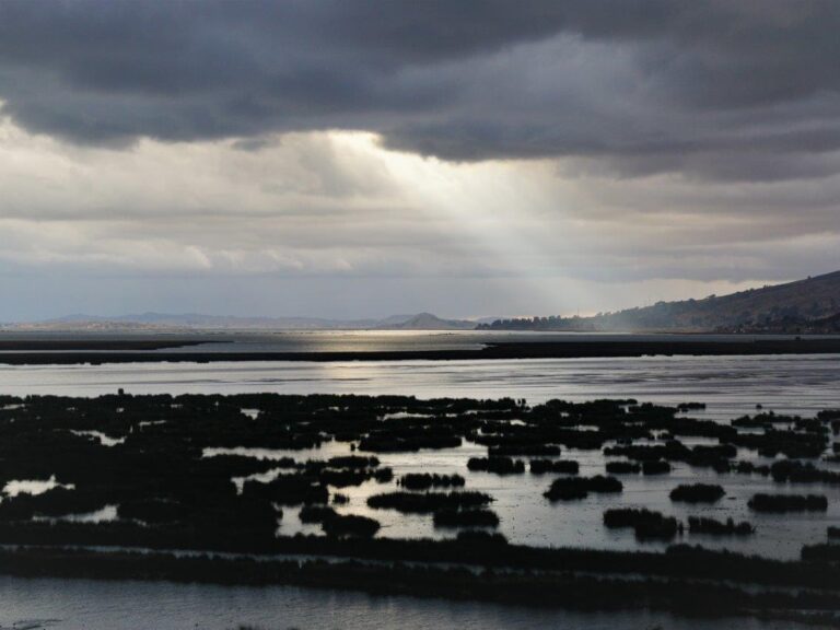 Blick auf den Titicaca-See unter dunklen Wolken.