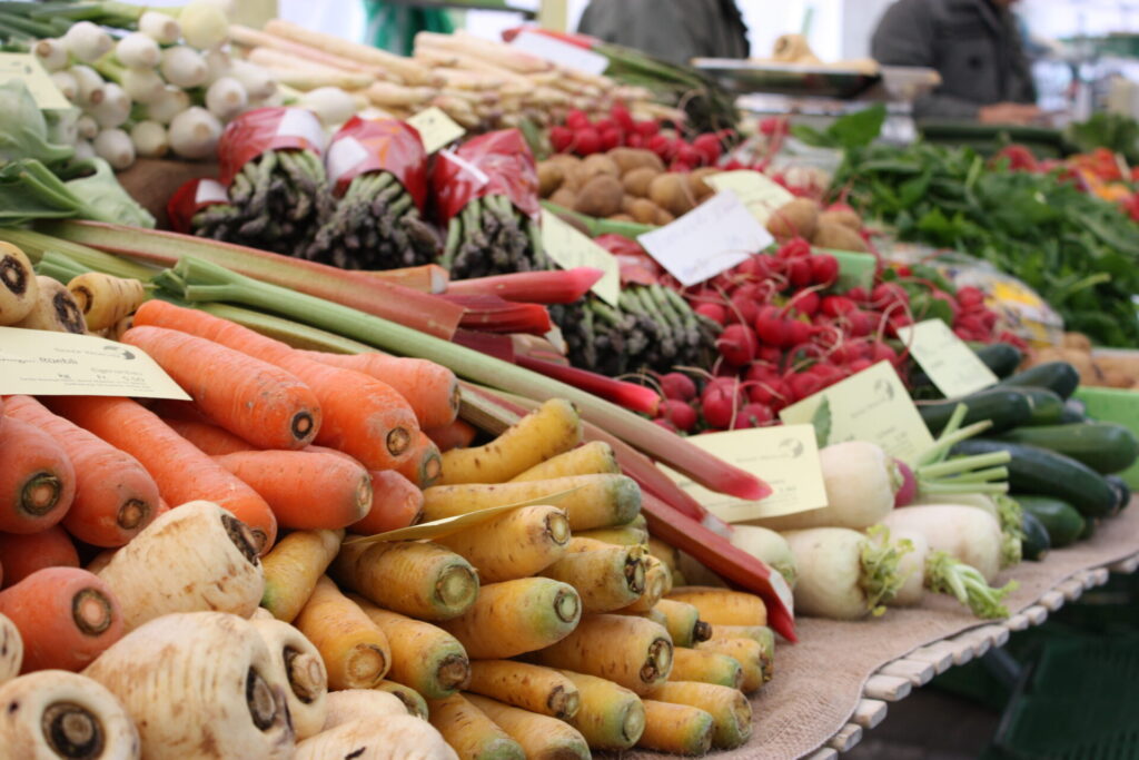 Seitlicher Blick auf einen Marktstand mit Wurzelgemüse.
