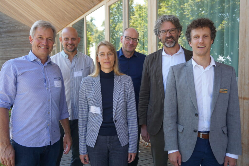 Eine Gruppe von fünf Männern und einer Frau schaut in die Kamera.