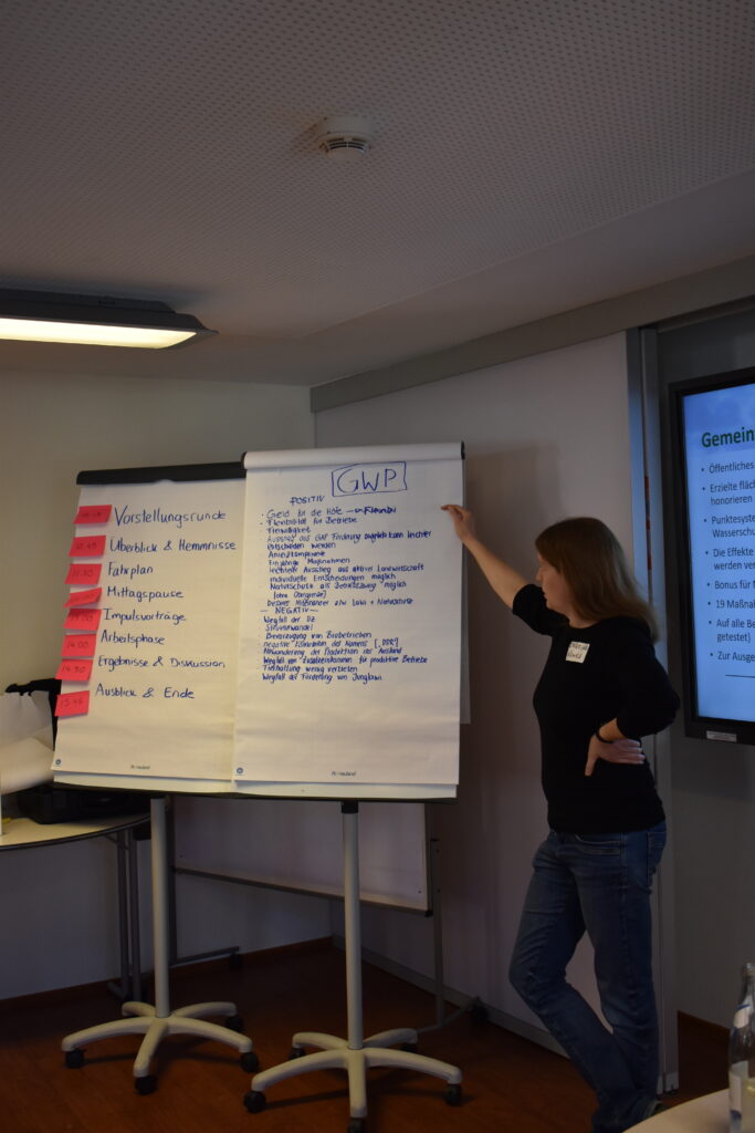 Eine Frau steht neben einer Flipchart.
