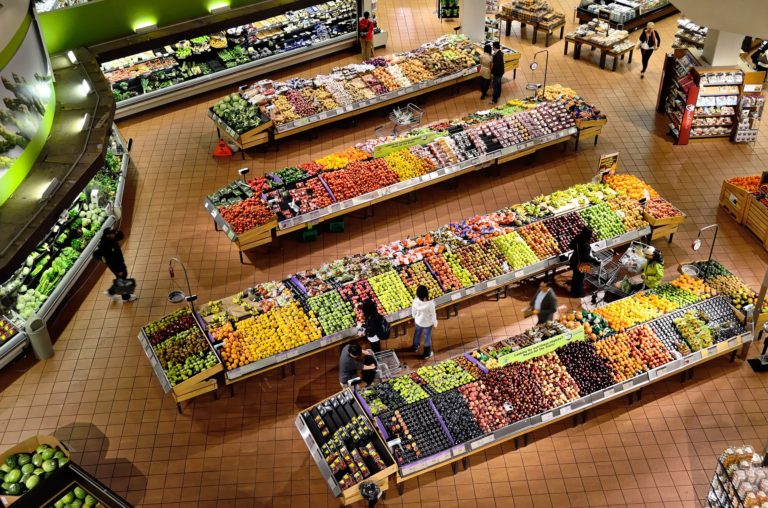 Vogelperspektive auf die Gemüse- und Obstabteilung eines Supermarkts.