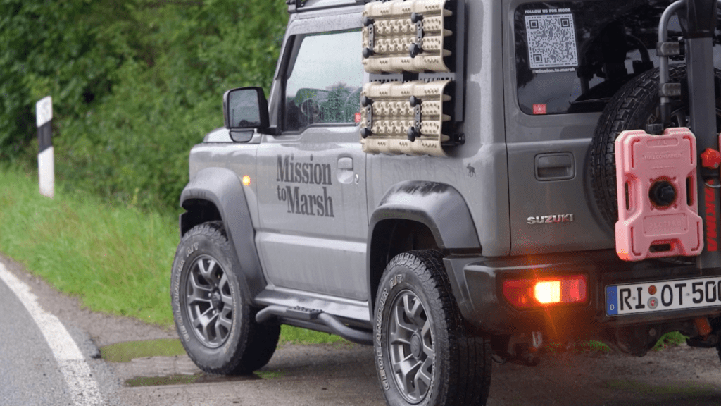 Filmszene: Ein Geländewagen in Seitenansicht mit der Aufschrift "Mission to Marsh"