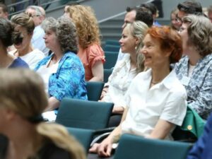 Blick ins Publikum. Zu sehen sind Frauen, die aufmerksam in eine Richtung blicken.