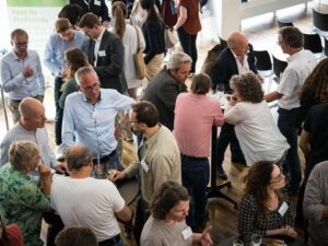 Blick von oben auf Gruppen von Konferenzteilnehmern, die sich unterhalten.