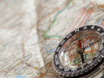 Blick auf eine unscharfe Landkarte, auf der ein Kompass liegt