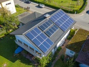 Blick auf das Dach eines Mehrfamilienhauses mit einer PV-Anlage.